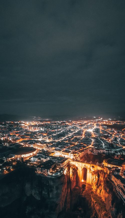 Free Stunning aerial view of Ronda at night, showcasing illuminated buildings and famous bridge. Stock Photo