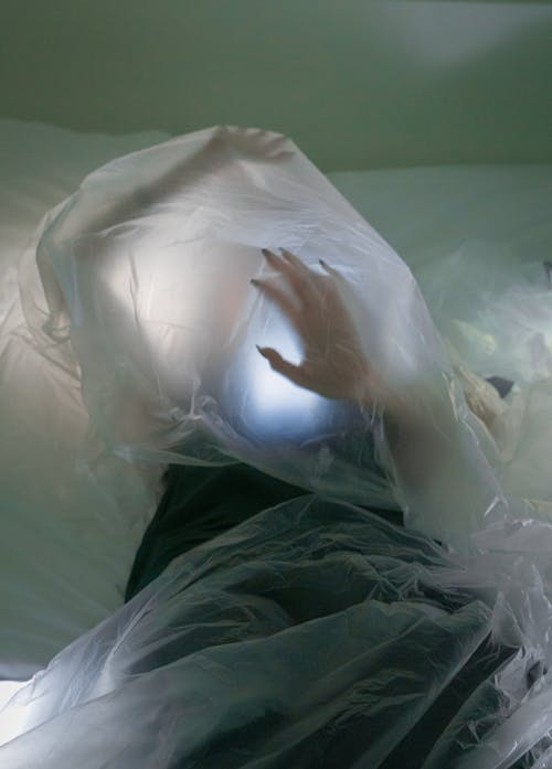 Photo of a Woman Covered by Plastic Foil