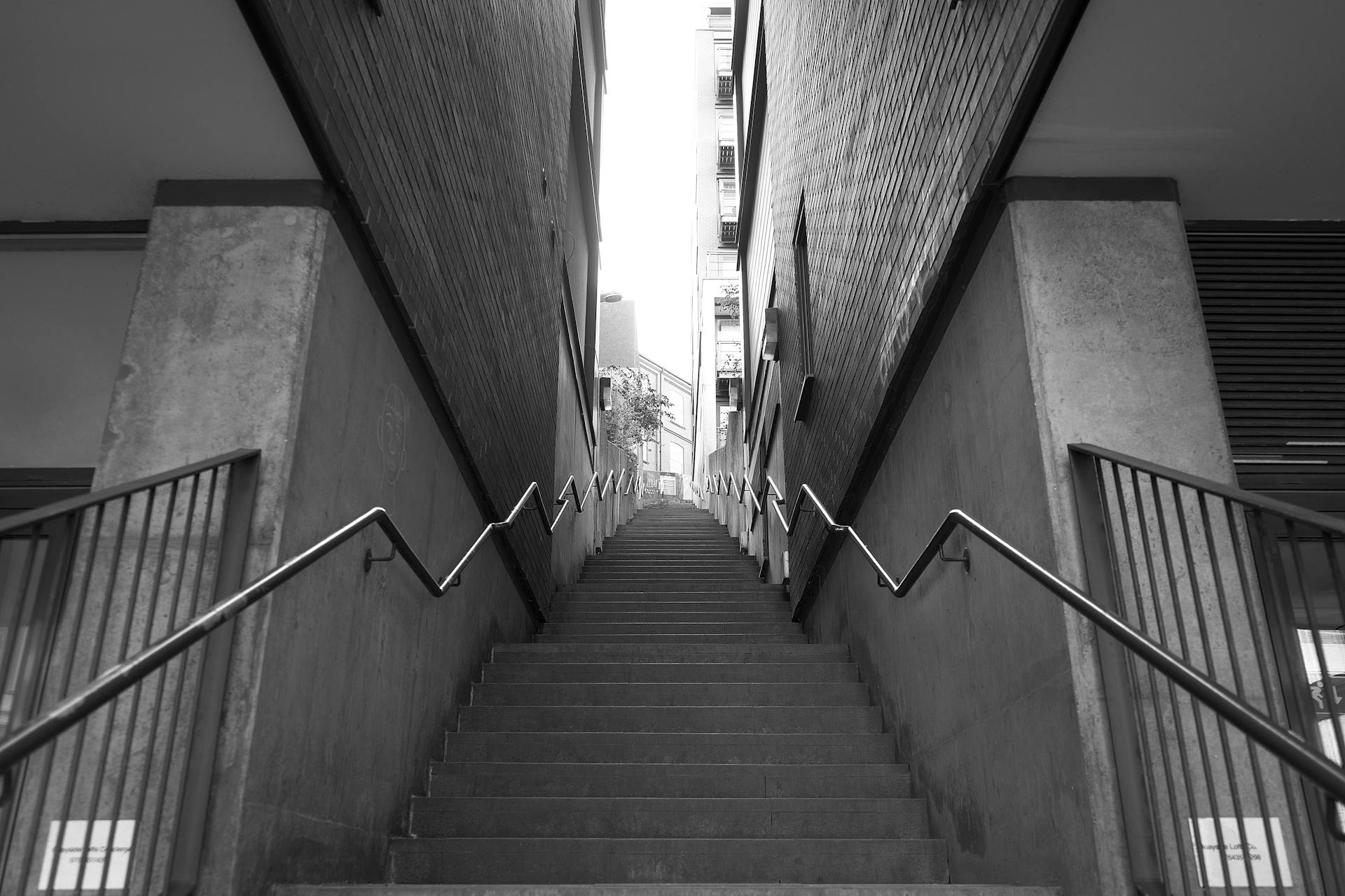 Black and white photo of a symmetrical urban staircase with railings in Newcastle upon Tyne, England.