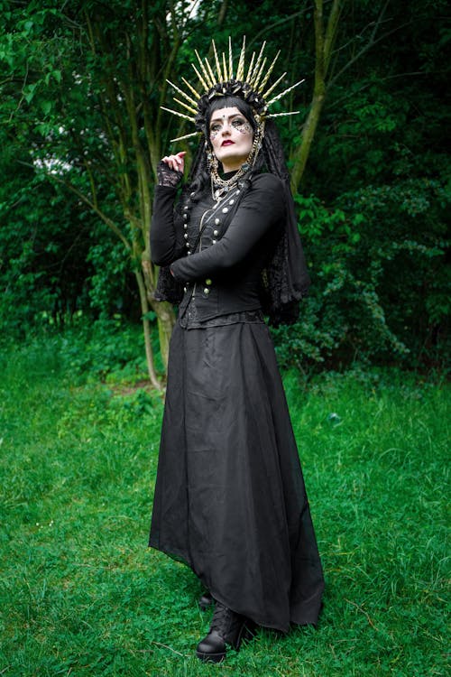 Woman in Black Long Sleeve Dress Standing on Green Grass 