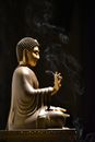 Figurine of Sitting Budda with lit incense