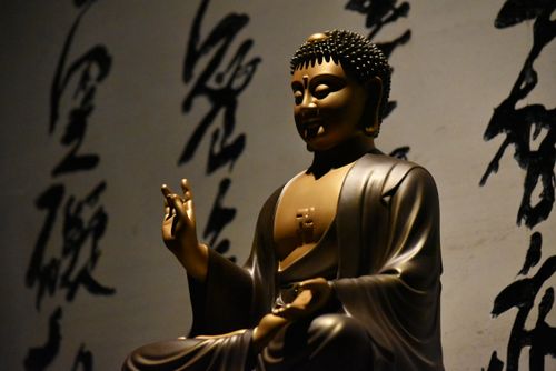 Free A serene Buddha statue surrounded by artistic calligraphy, symbolizing spirituality. Stock Photo