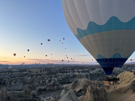 A stunning view of hot air balloons soaring over Cappadocia's unique landscape during sunrise.