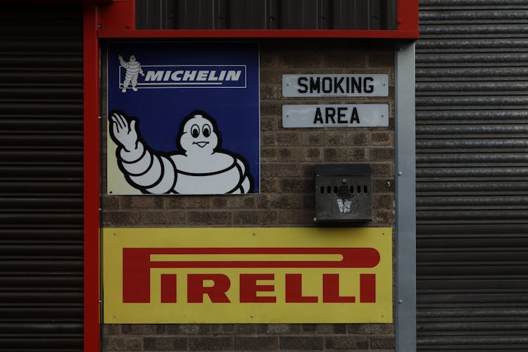 Pirelli And Michelin Logos On Wall