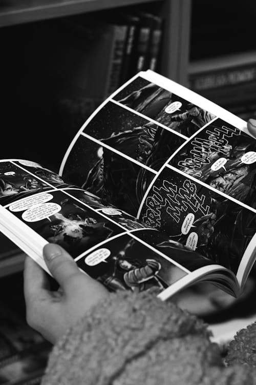 A Grayscale of a Person Reading a Comic Book