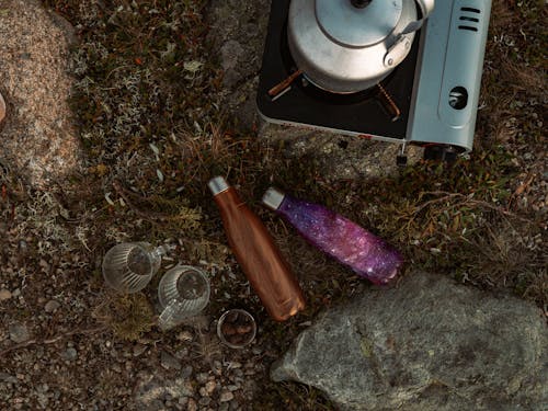 Water Bottles and Cups Near the Stove on the Ground