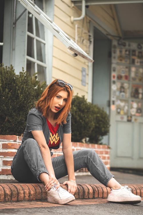 Free Redhead Woman Sitting on Sidewalk Stock Photo