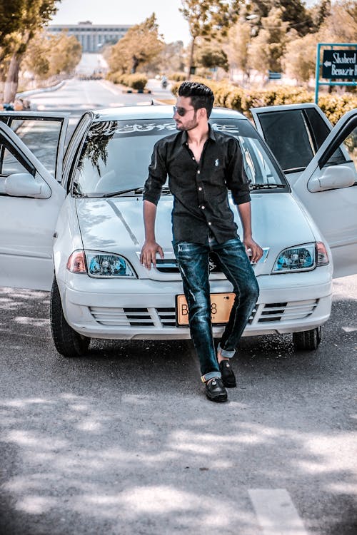 Homme Assis Sur Le Capot De La Voiture Blanche