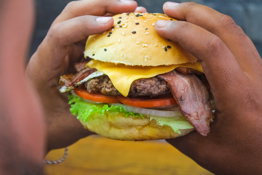 Delicious cheeseburger with bacon, lettuce, tomato, captured in a close-up shot.