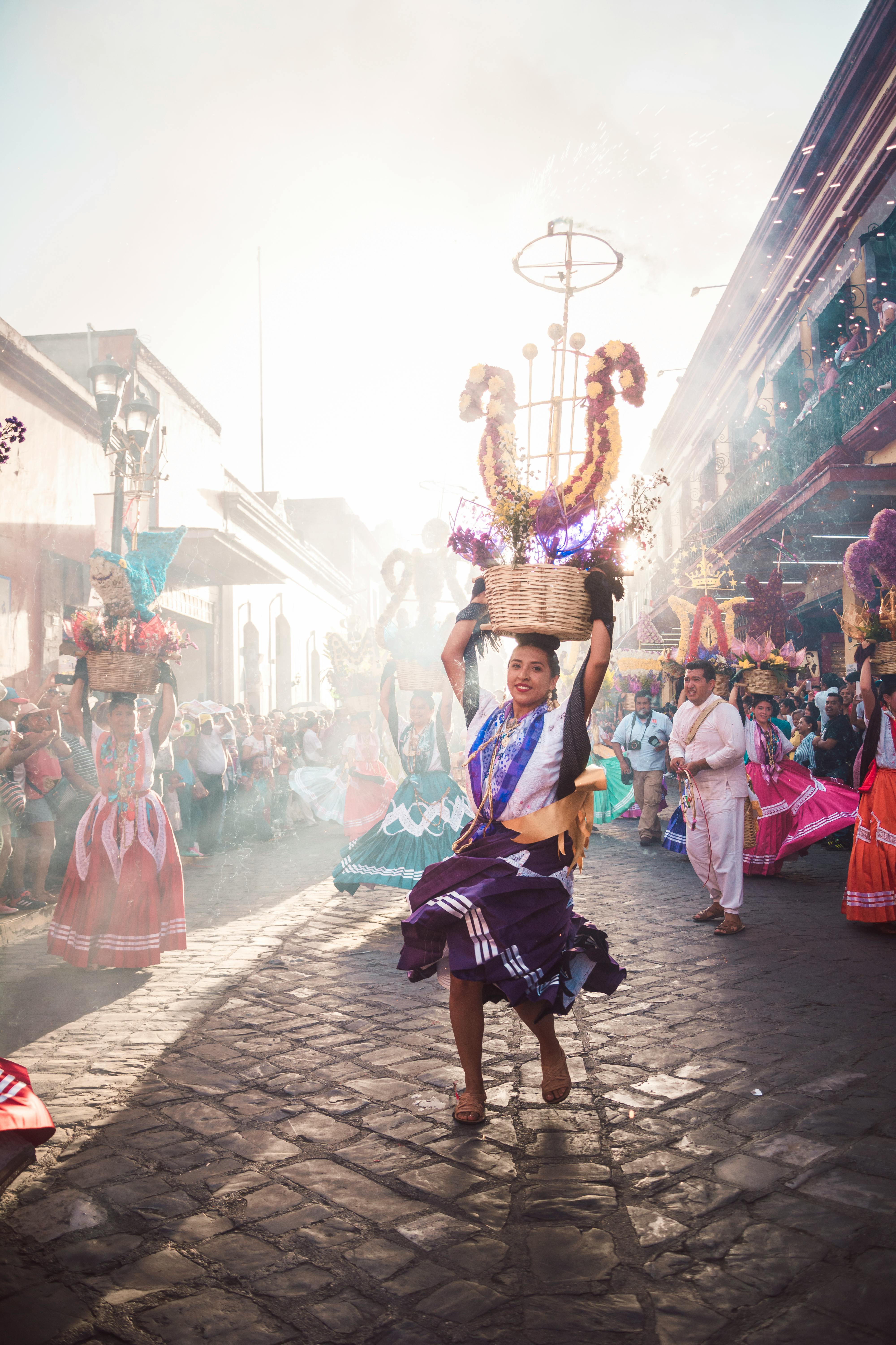 Woman dancing at a colorful festival in Oaxaca, celebrating Mexican culture.
