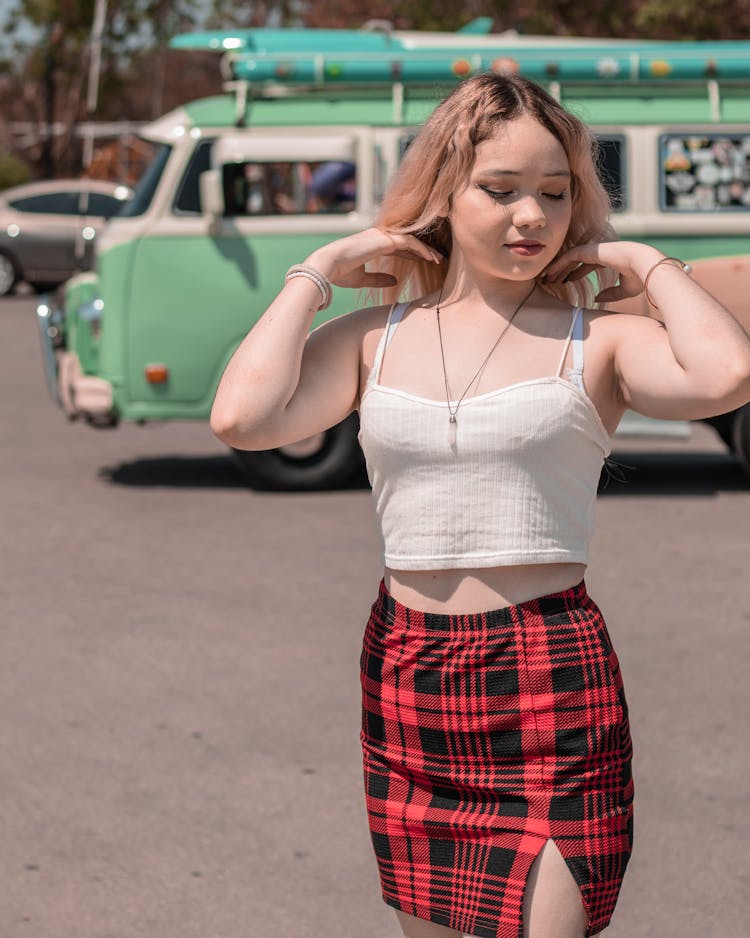 Woman In White Sleeveless Top And Plaid Skirt