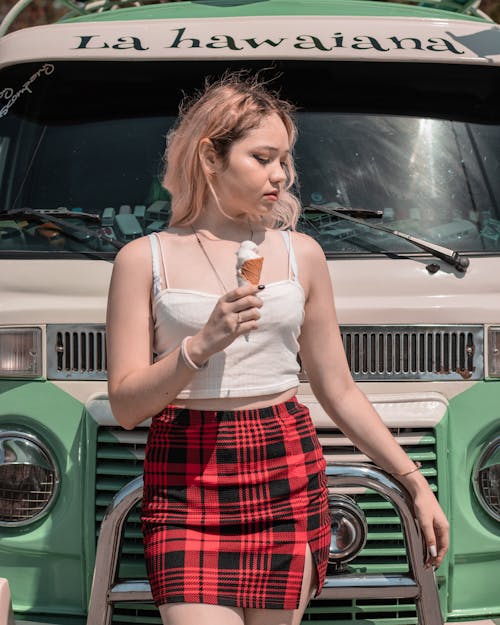 Woman Holding an Ice Cream in Front of a Vehicle