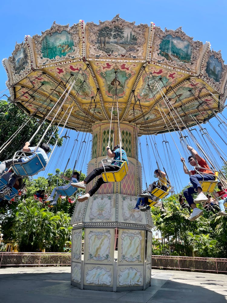 People Riding On Swing Carousel