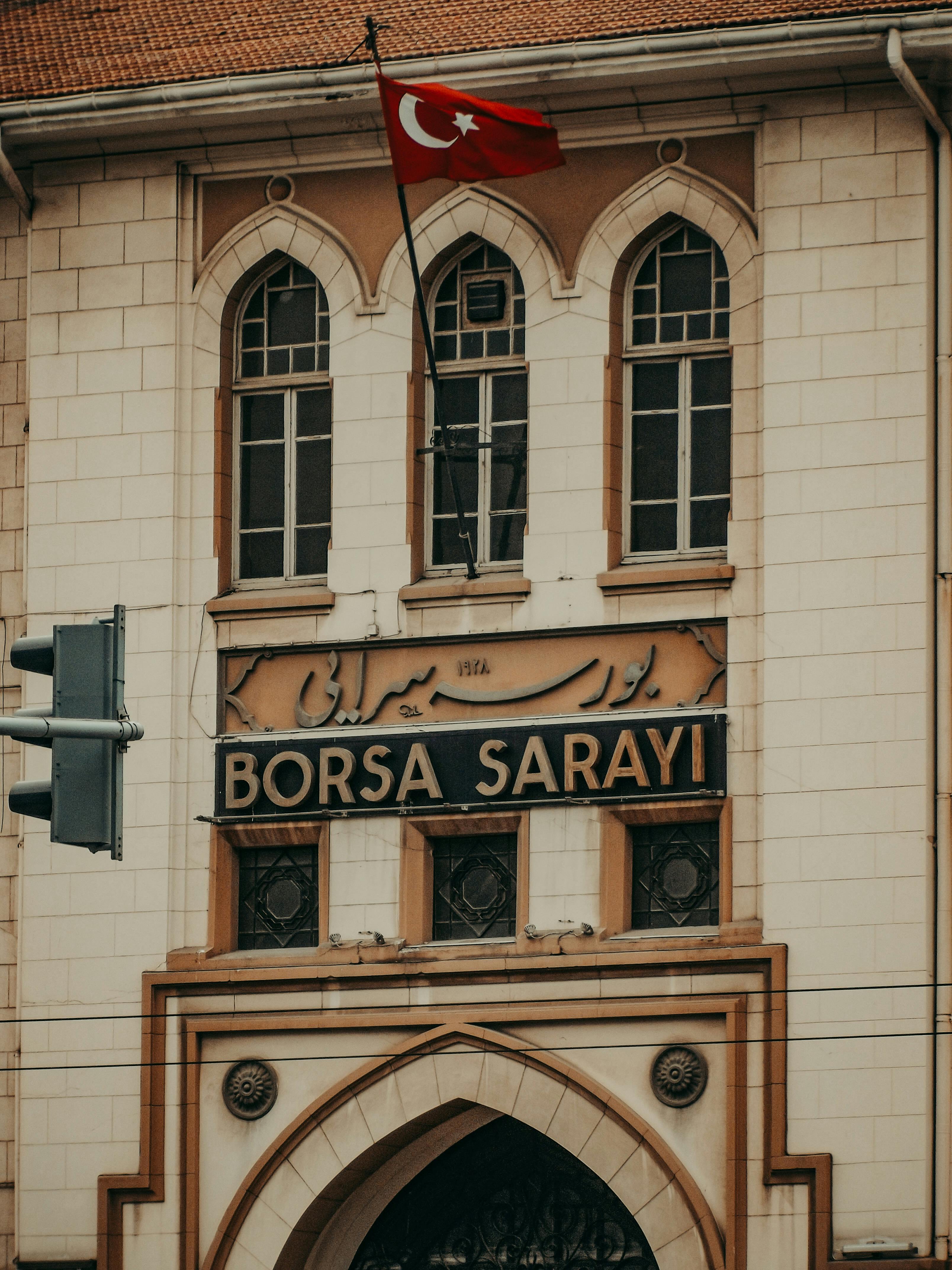 Facade of Borsa Sarayi displaying Turkish flag and architectural details.