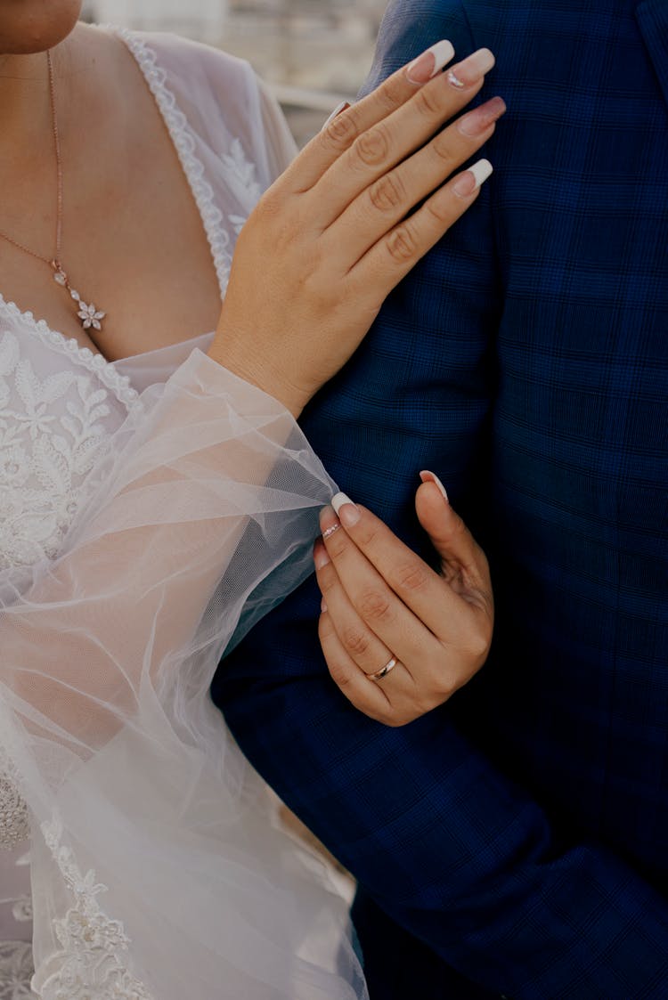 Close Up Of Bride Hands Holding Grooms Arm