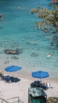Beautiful beachfront with blue umbrellas on a sunny day in Rhodes, Greece.