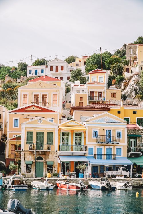 Free Vibrant houses and boats along the waterfront in picturesque Symi, Greece. Stock Photo