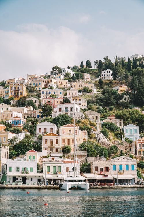 Free Picturesque hillside village with colorful houses by the sea in Greece. Stock Photo
