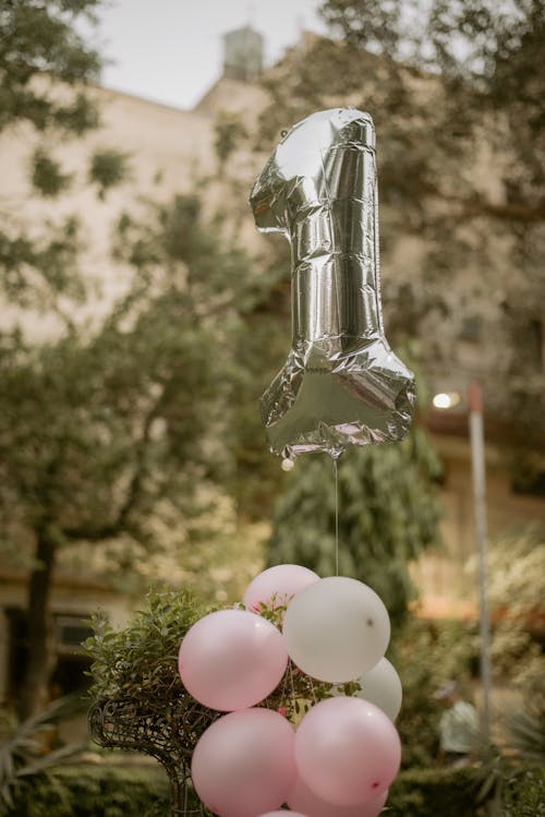 Silver Number 1 Balloon and Pink Balloons Tied Together for the 1st Birthday Celebration