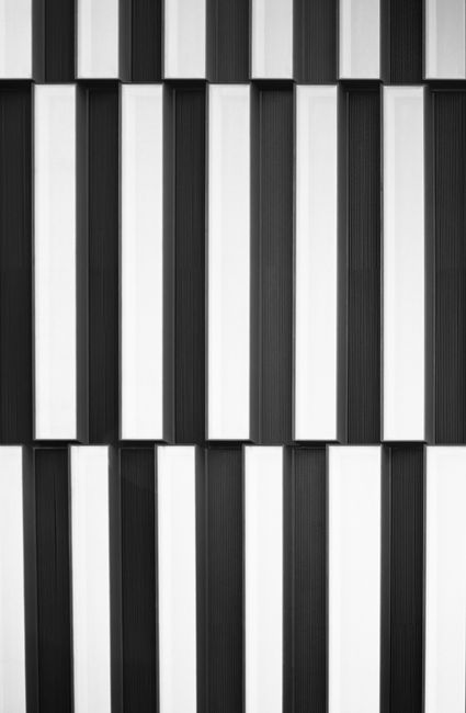 Stylish black and white vertical geometric pattern on a modern building facade.