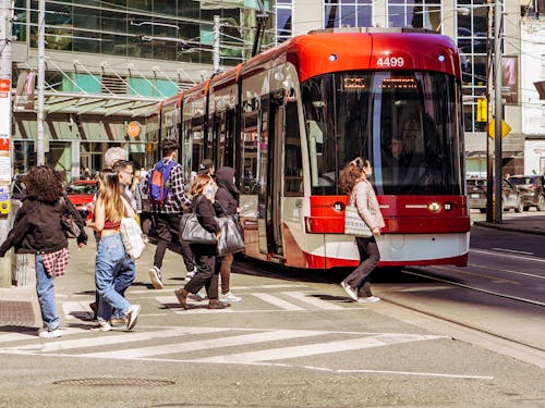 People Walking near Red Tram