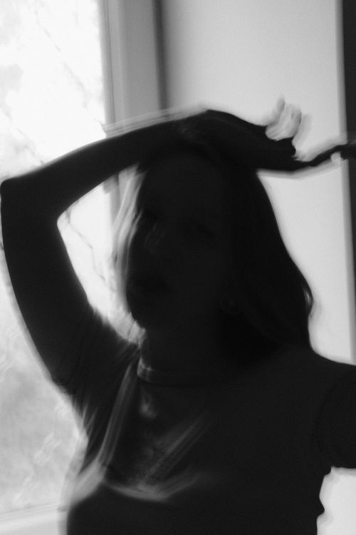 Free Silhouetted woman in monochrome posing by a window, evoking mystery. Stock Photo