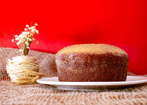 Free Moist homemade cake on a white plate with rustic burlap and red backdrop, perfect for food photography. Stock Photo