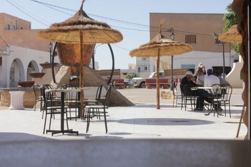 Free Outdoor café with straw umbrellas and tables on a sunny day in Médenine, Tunisia. Stock Photo
