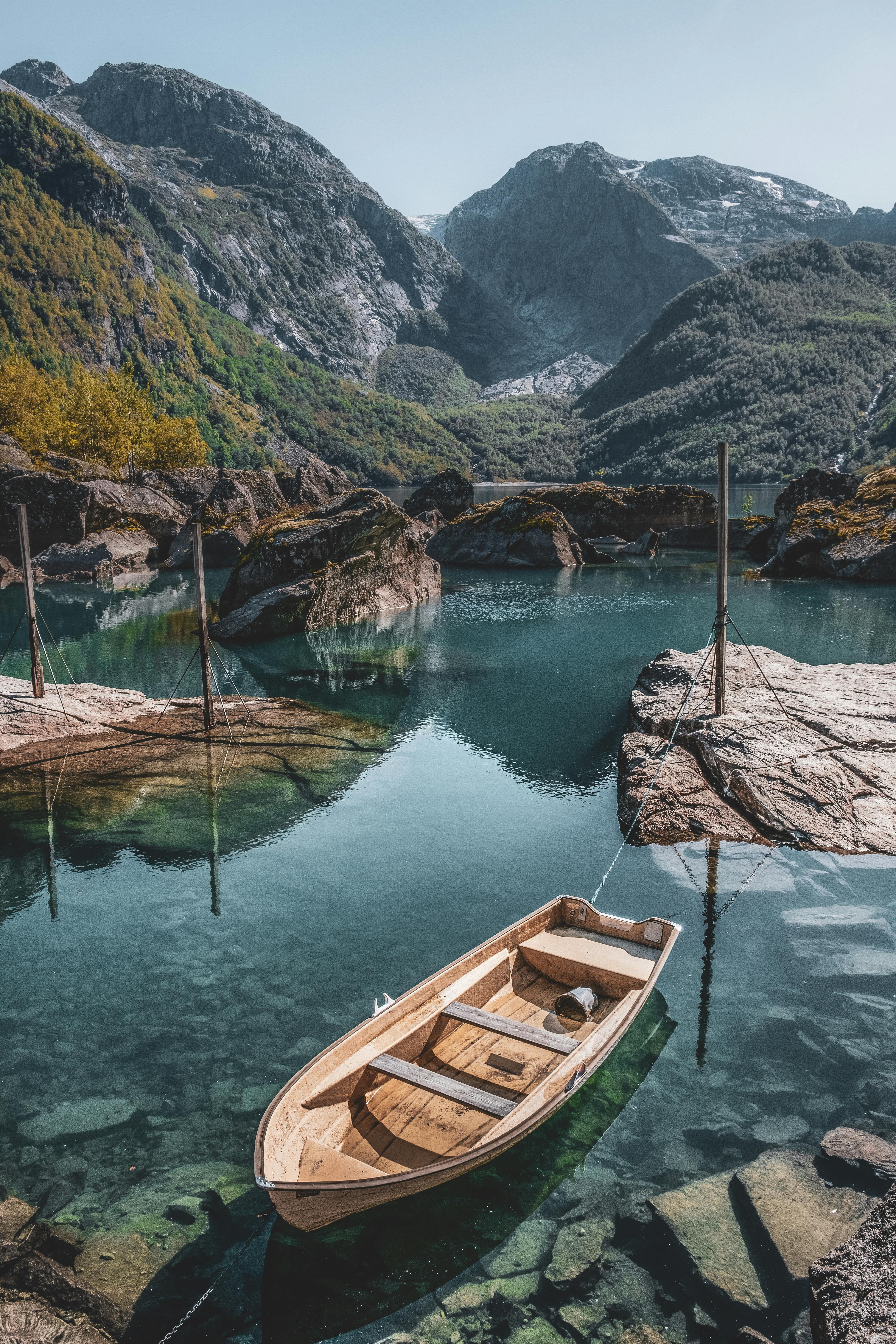 Tranquil scene of a wooden boat on a clear lake in Vestland, Norway.