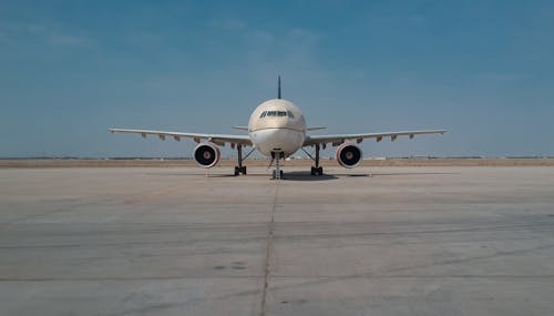 Front View of an Airplane on Tarmac Under Blue Sky
