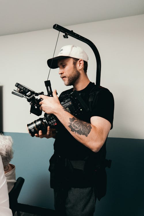 Man in Black Crew Neck T-shirt Holding Black Dslr Camera