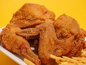Golden fried chicken pieces stacked over fries — photo by Gonzalo Ruiz on Pexels