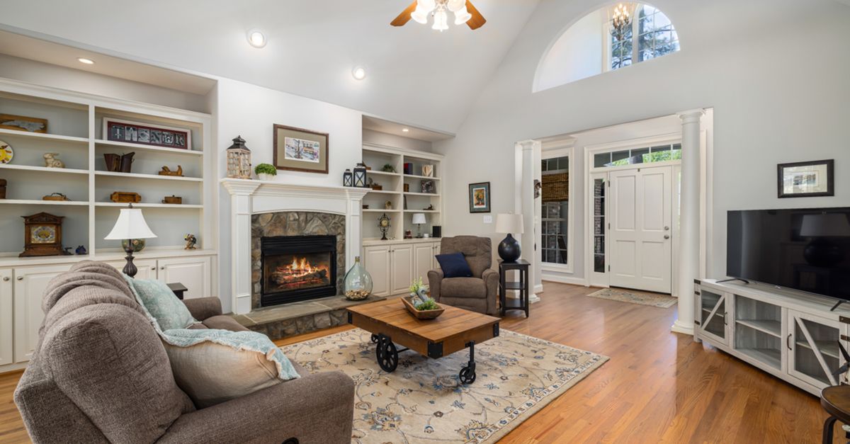 Elegant living room with fireplace, vaulted ceiling, and warm decor for a welcoming atmosphere.