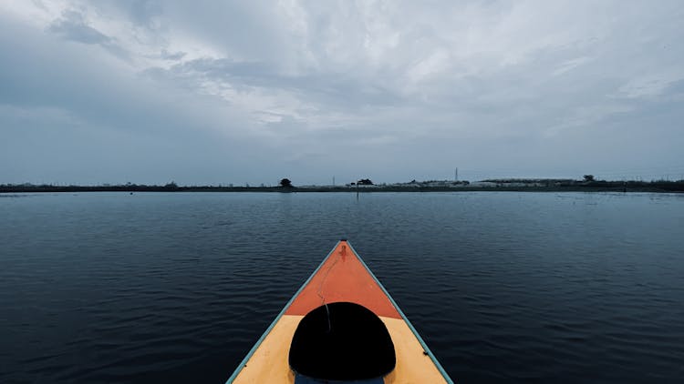 Kayak On Body Of Water Under Cloudy Sky