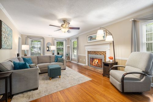 Free Bright living room featuring a classic fireplace, cozy armchair, and elegant decor. Stock Photo