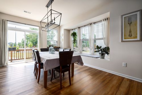 Free Spacious dining room with wooden floor, natural light, and elegant decor. Stock Photo