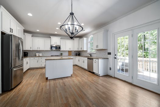 Bright, contemporary kitchen featuring sleek white cabinetry and a central island with ample natural light.