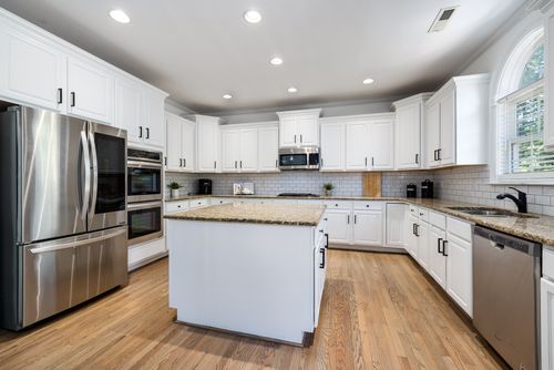 Free Modern kitchen featuring white cabinets, granite countertops, and stainless steel appliances. Stock Photo