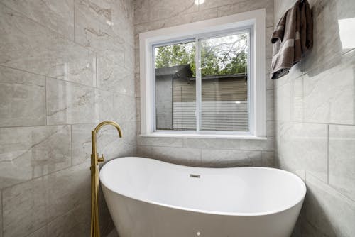 White Ceramic Bathtub Near White Framed Glass Window