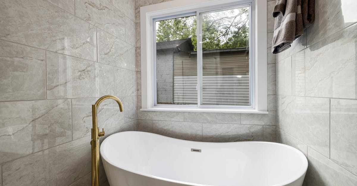 White Ceramic Bathtub Near White Framed Glass Window