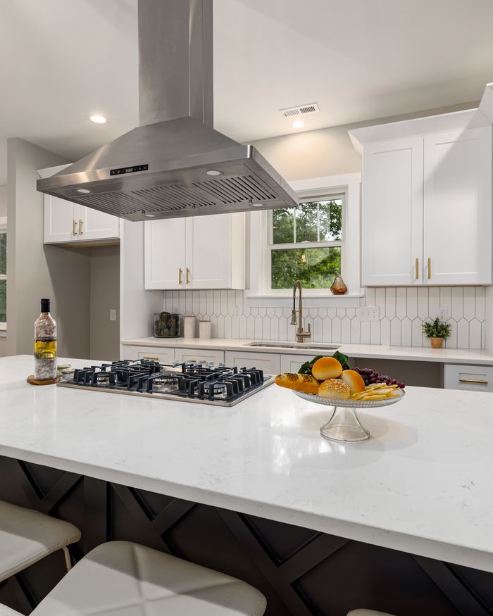 Modern kitchen with a stainless steel range hood above the stove Modern kitchen with a stainless steel range hood above the stove