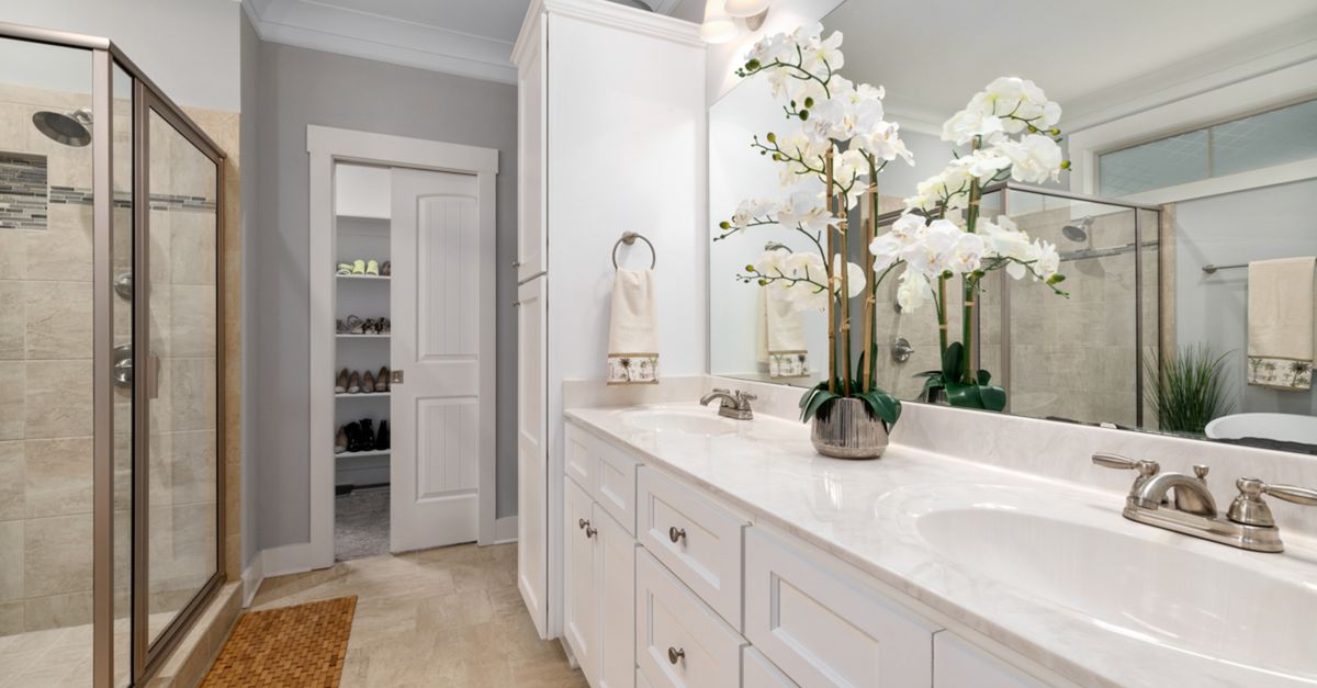 Sleek contemporary bathroom featuring double vanity and glass shower with elegant decor.