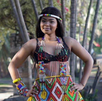 一位身着鲜艳祖鲁服装的年轻女子在户外自信地微笑着摆姿势