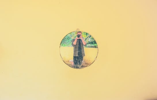 通过芥末墙上圆形镜子拍摄一个人的艺术镜头