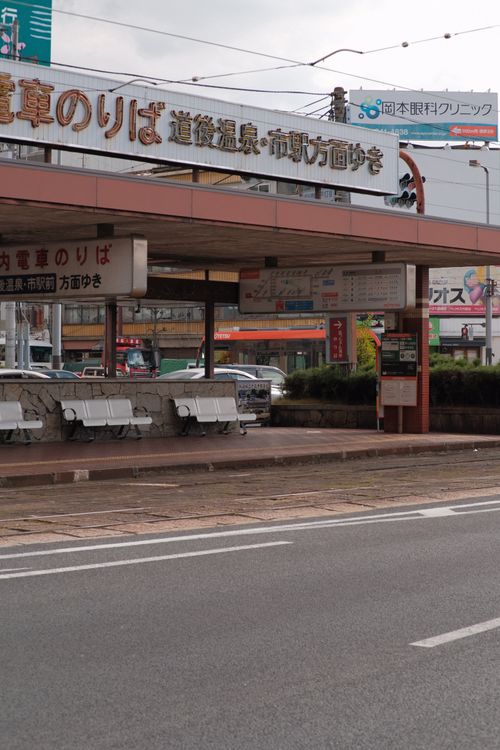 Free View of an urban bus station with benches and signage in a city setting. Stock Photo