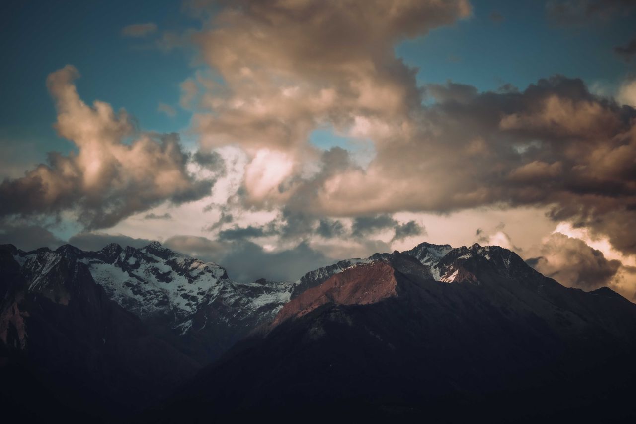 stunning mountain peaks under a dramatic cloudy sky at twilight perfec