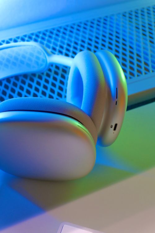 Free Close-up of sleek white headphones basking in ambient blue light, showcasing modern design. Stock Photo