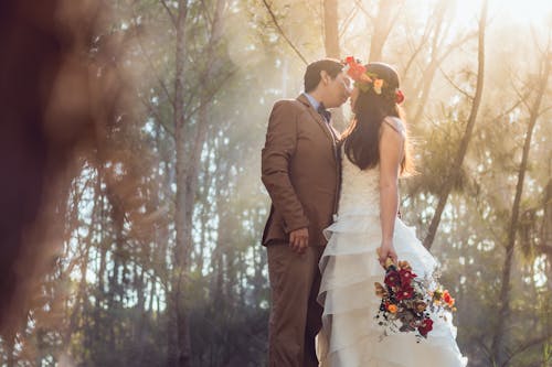 A Bride and Groom Kissing at Each Other 