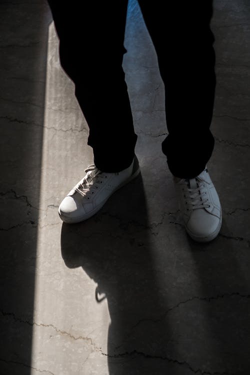 Person in Black Pants Wearing White Shoes 