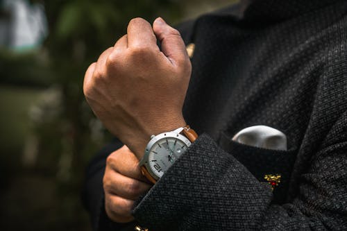 Person in Black Suit Wearing Leather Strap Wristwatch